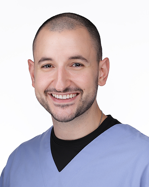 a man with a wide smile and a blue shirt