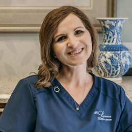 a smiling girl with a curly hair wearing a blue shirt