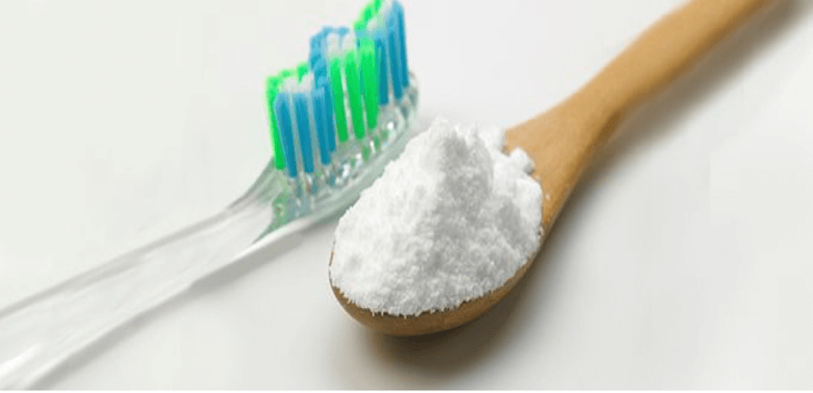 a toothbrush and a spoon of baking soda