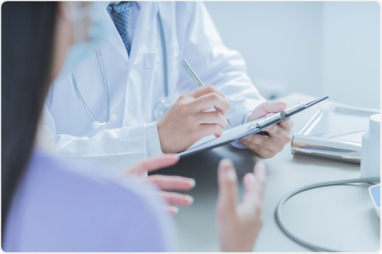 a doctor holding a pen and paper taking a prescription