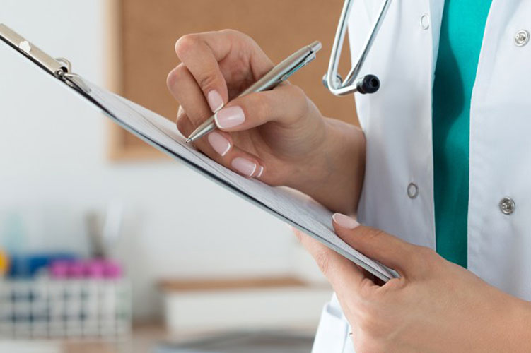 a doctor holding a pen and paper taking notes