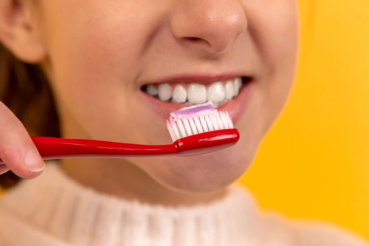 a girl holding a toothbrush