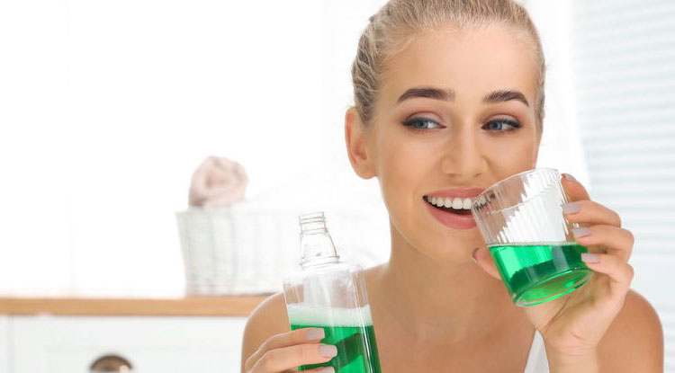 a girl holding a bottle and cup of green liquid