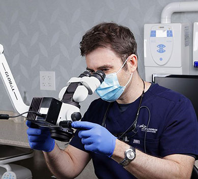 doctor looking through a microscope